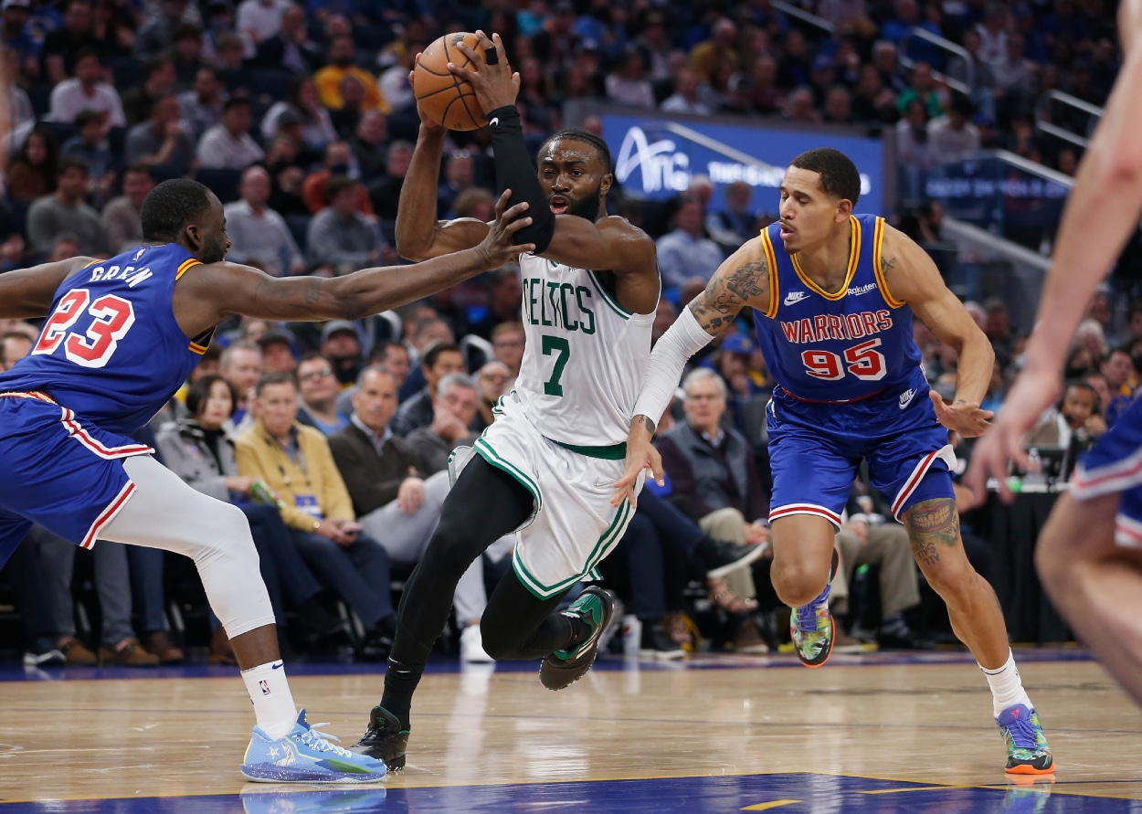 Jaylen Brown #7 of the Boston Celtics drives to the basket in the fourth quarter against Juan Toscano-Anderson #95 and Draymond Green #23 of the Golden State Warriors.