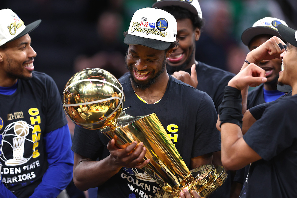 Andrew Wiggins of the Golden State Warriors holds the Larry O'Brien Championship Trophy after defeating the Boston Celtics in the 2022 NBA Finals