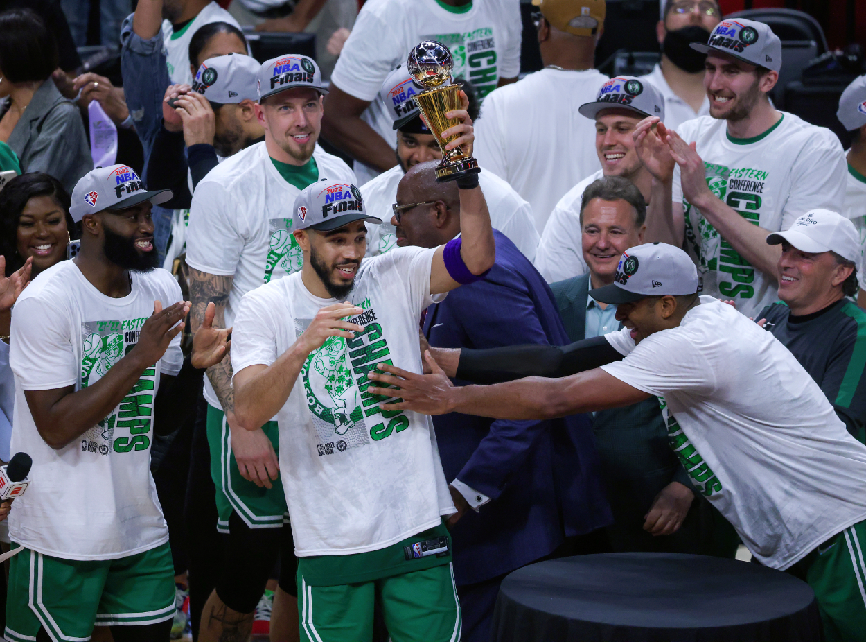 Boston Celtics forward Jayson Tatum lifts the MVP trophy after his team defeated the Miami Heat 100-96.