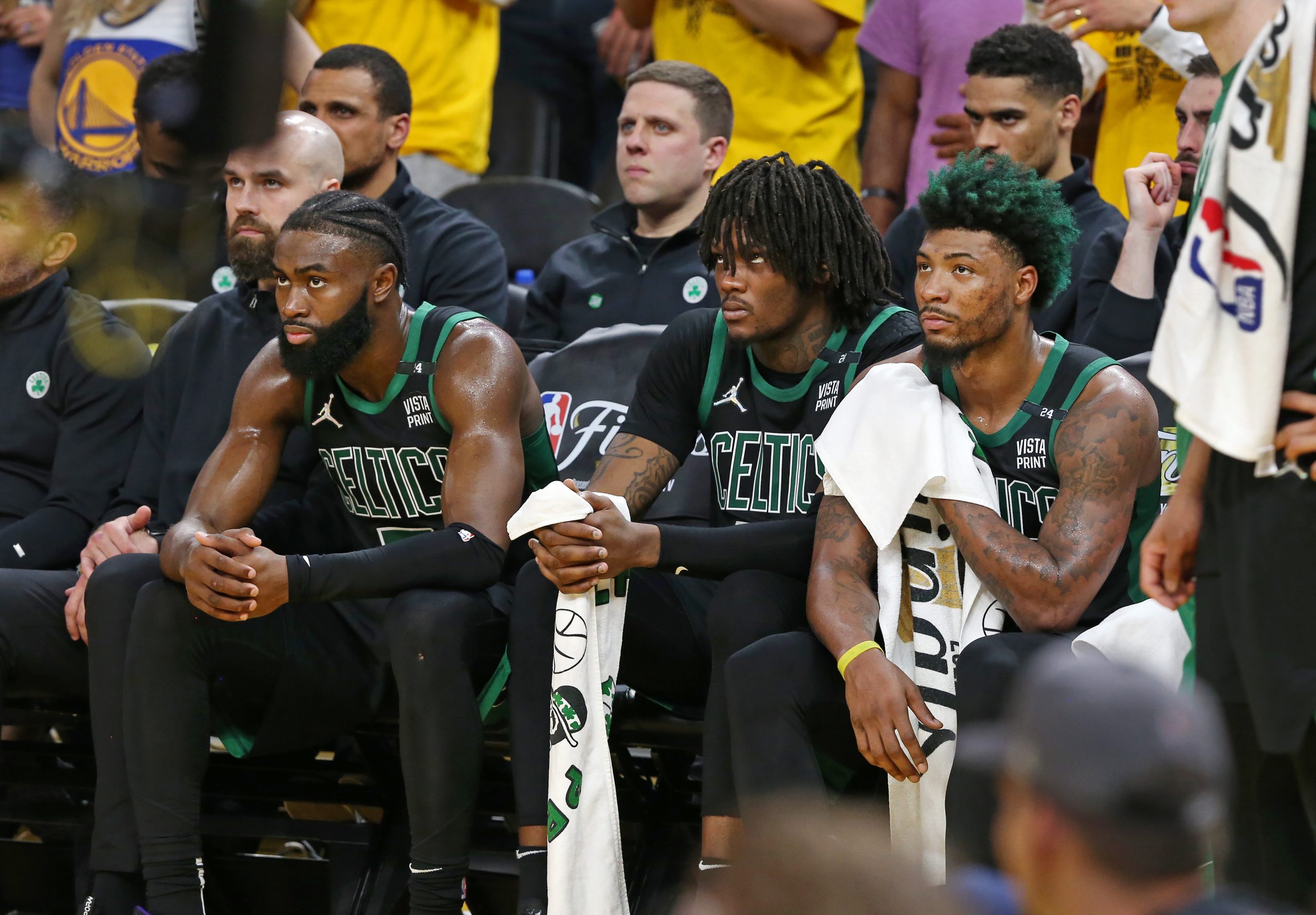 Jaylen Brown, Robert Williams, and Marcus Smart of the Boston Celtics are pictured on the bench.