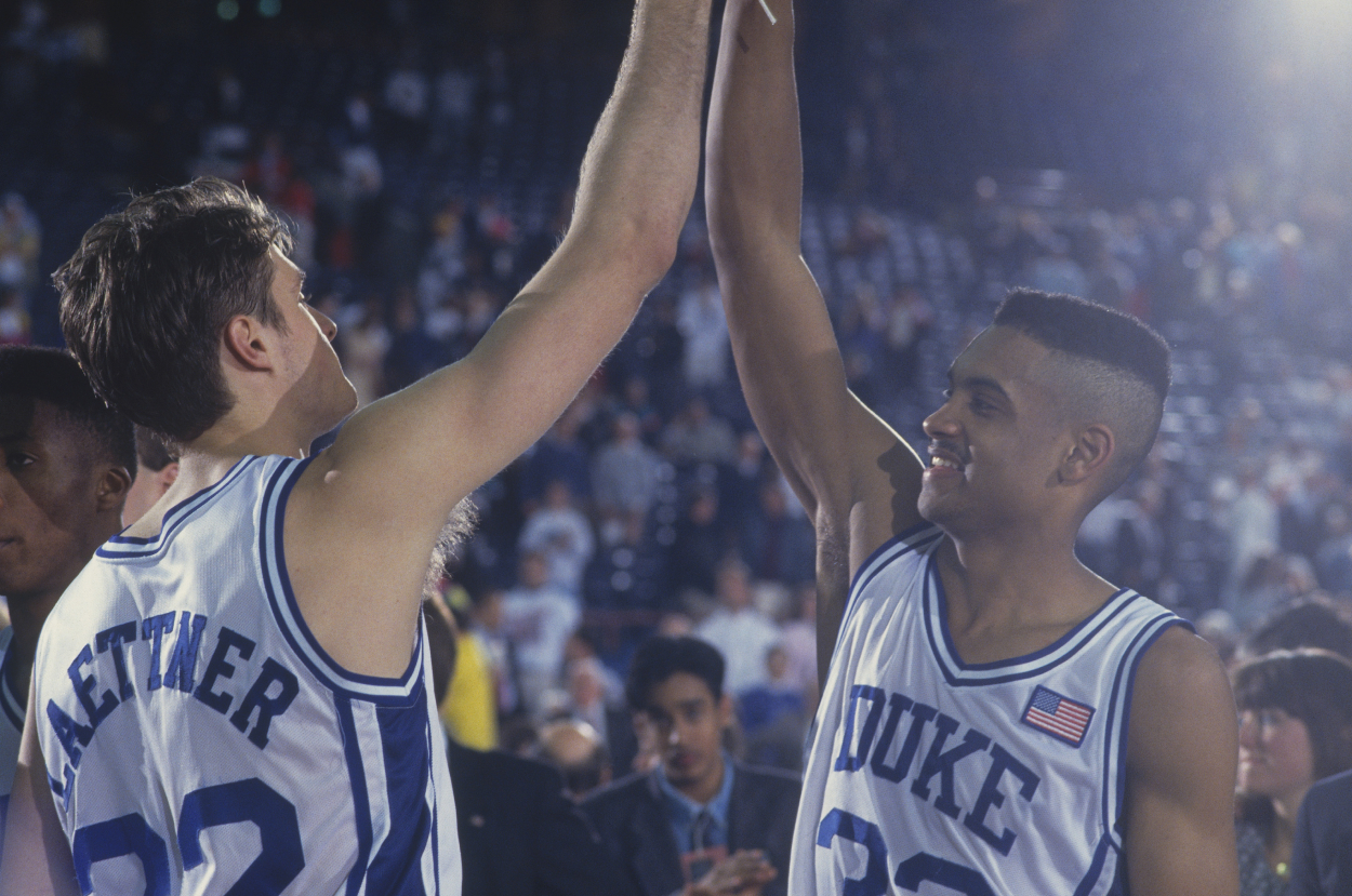 Duke players Grant Hill and Christian Laettner high-five each other.