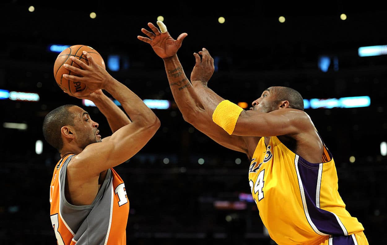 Grant Hill (L) attempts a jump shot over Kobe Bryant.