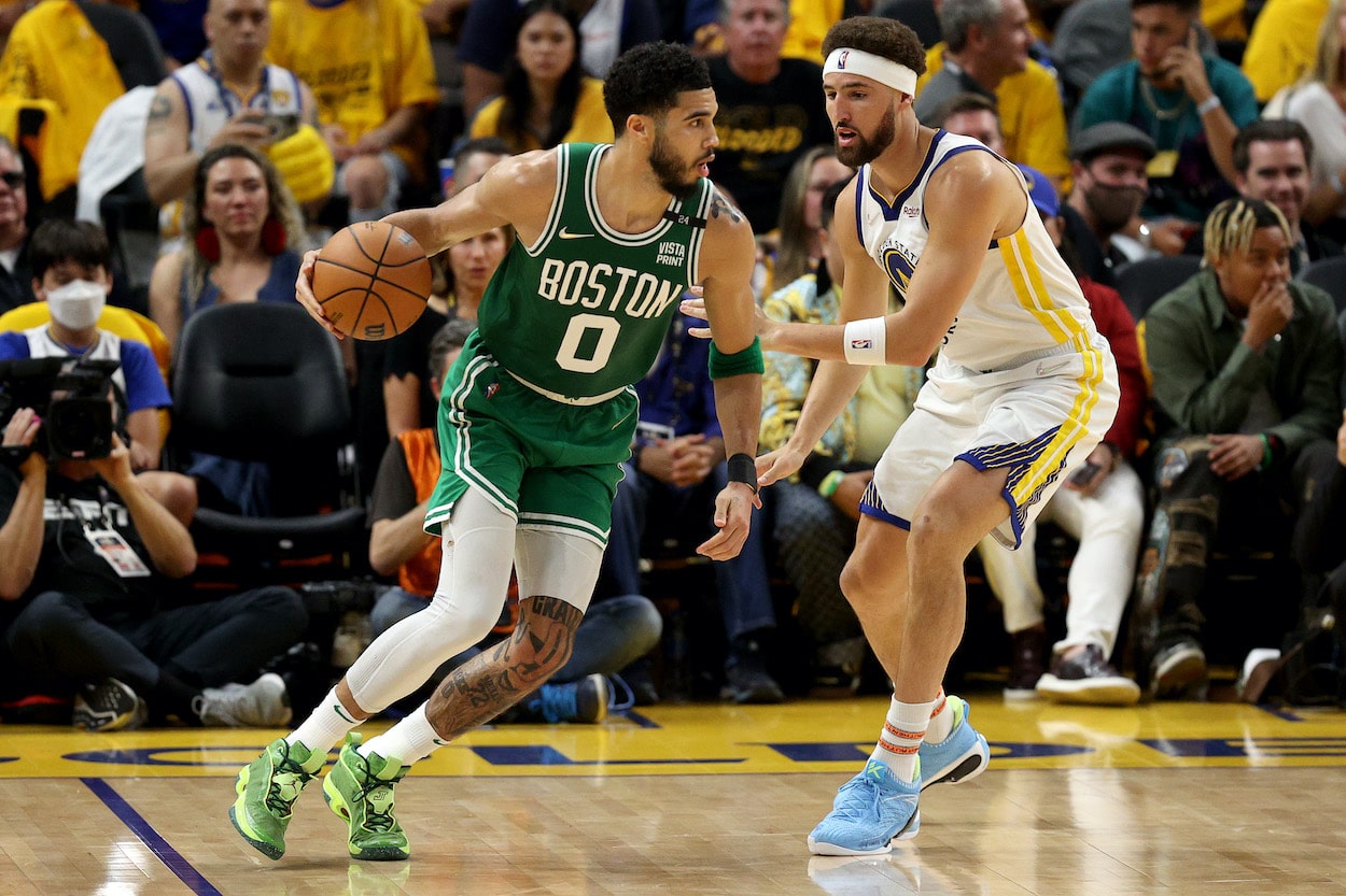 Jayson Tatum dribbles against Klay Thompson.