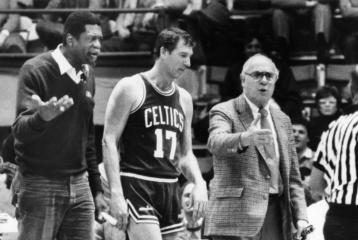 Boston Celtics green coach Bill Russell, left and white coach Red Auerbach, right, argue with an official as John Havlicek stands by.