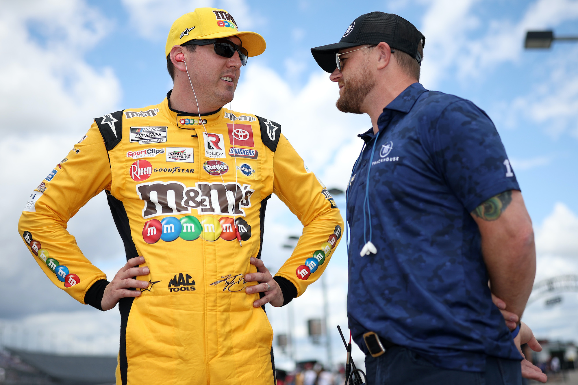 Trackhouse Racing team co-owner Justin Marks (R) and Kyle Busch talk on the grid during qualifying for the NASCAR Cup Series Goodyear 400 at Darlington Raceway on May 07, 2022. | Photo by James Gilbert/Getty Images