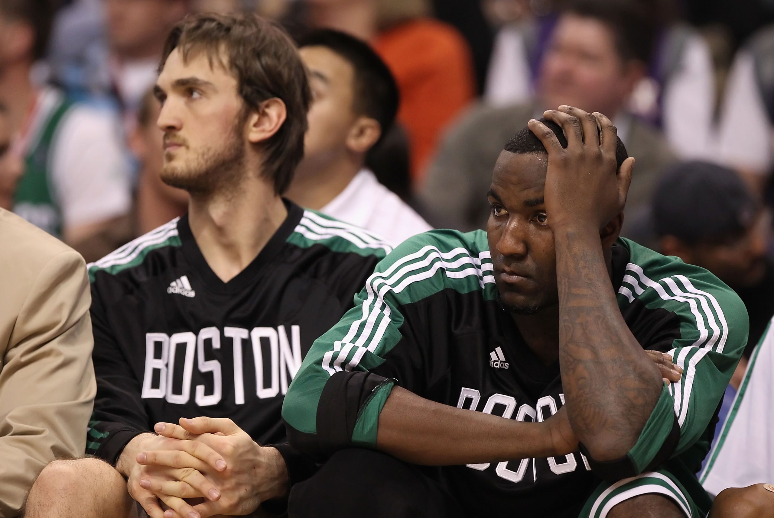 Kendrick Perkins, right, of the Boston Celtics reacts while sitting on the bench.
