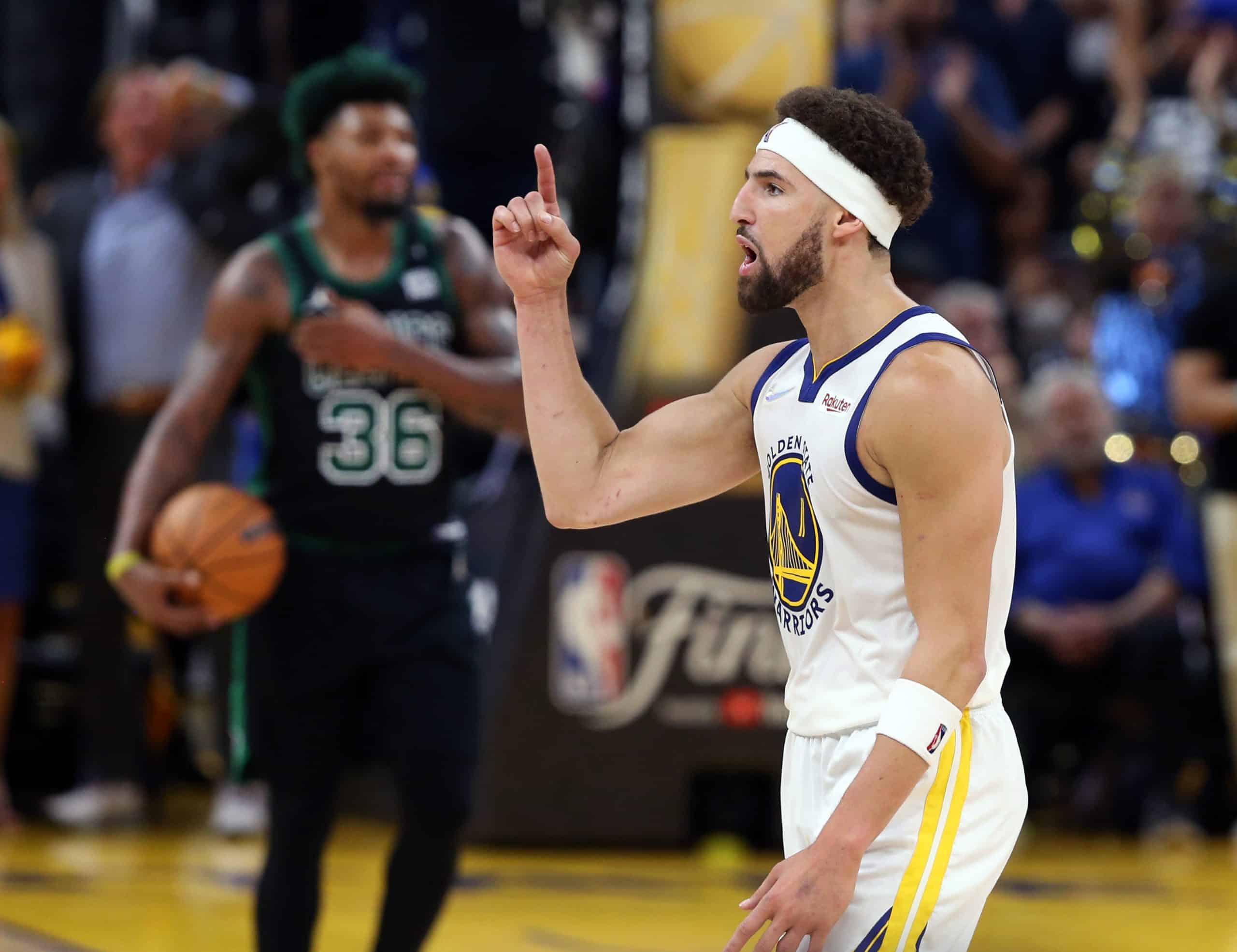 Klay Thompson gestures to the crowd.