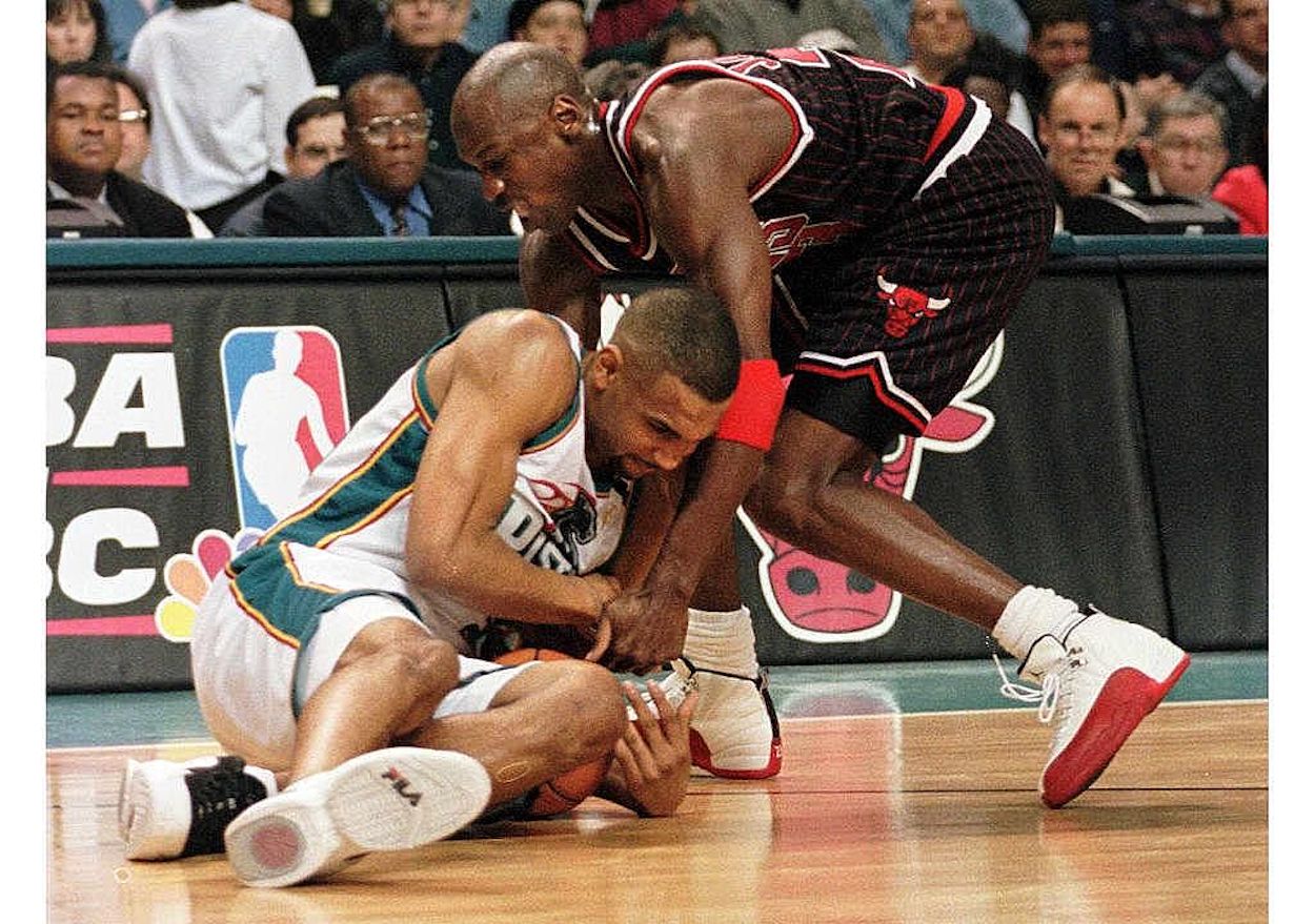 Grant Hill (L) and Michael Jordan (R) fight for a loose ball.