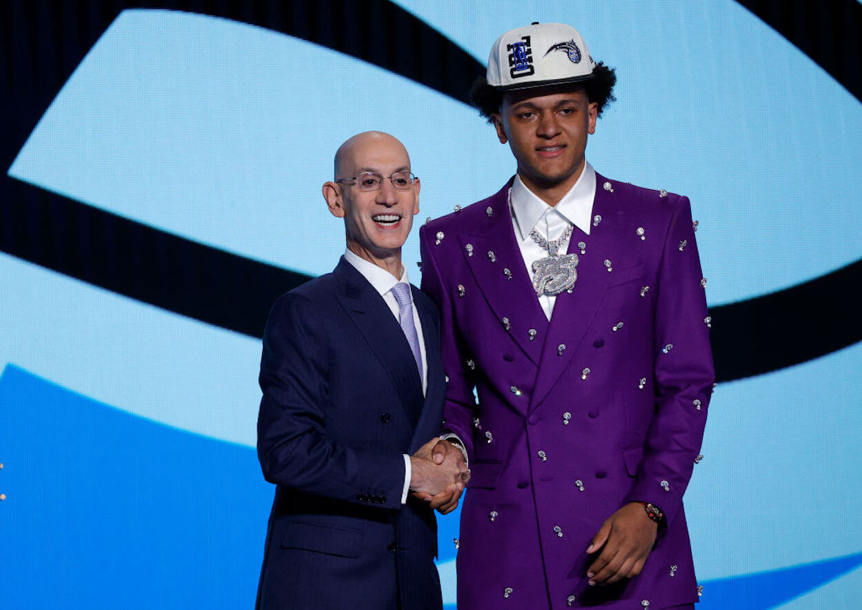 Paolo Banchero (R) poses with Adam Silver (L) after being drafted into the NBA.