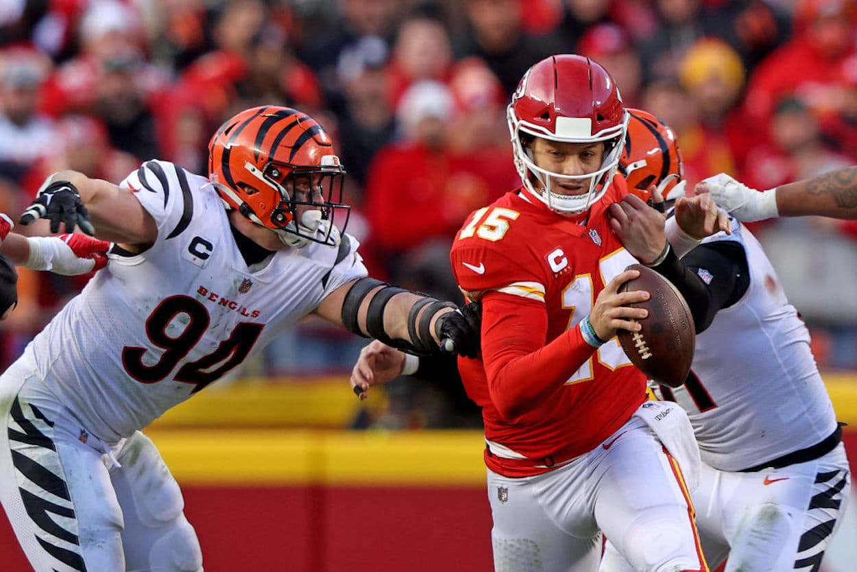 Kansas City Chiefs quarterback Patrick Mahomes runs from two Bengals defenders.