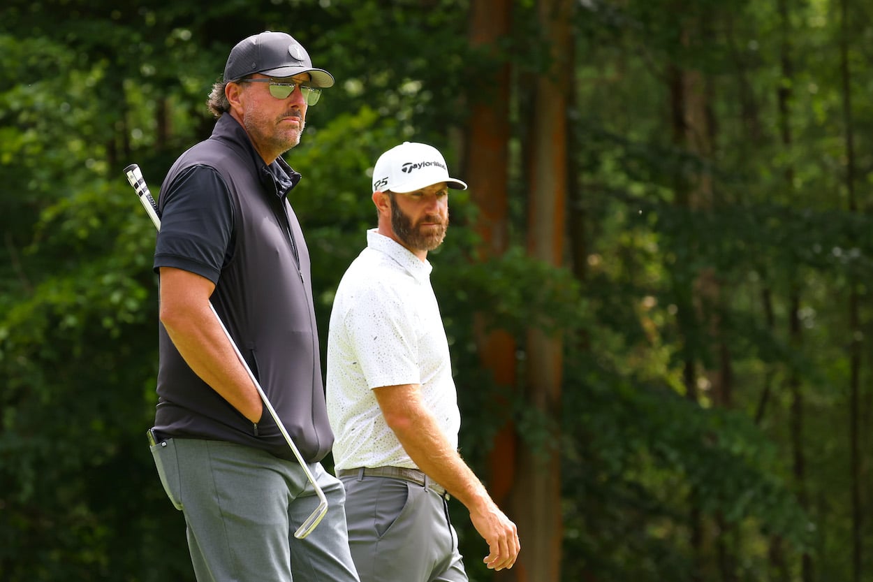 Phil Mickelson and Dustin Johnson look on during LIV Golf event.