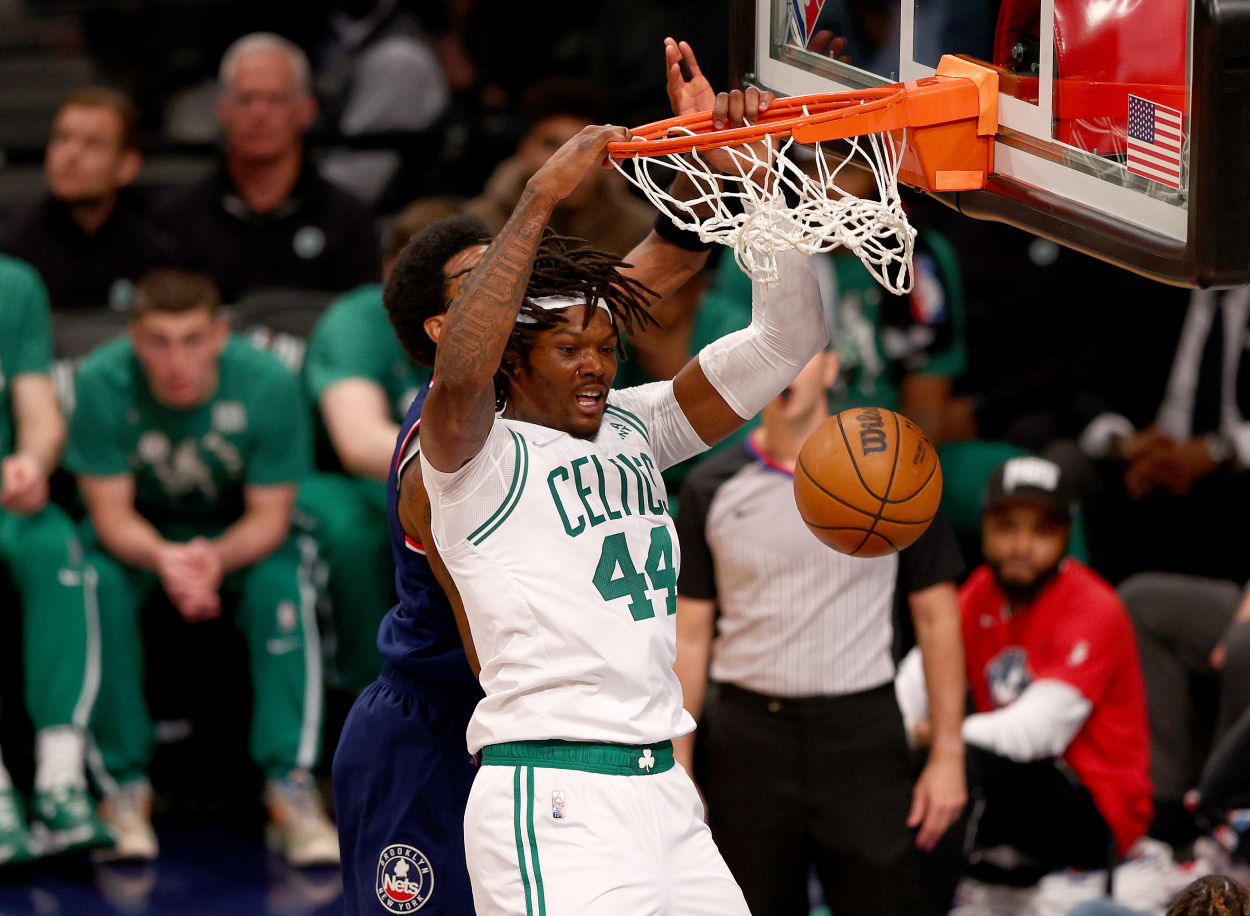 Robert Williams III of the Boston Celtics dunks in the third quarter as Kyrie Irving of the Brooklyn Nets defend.