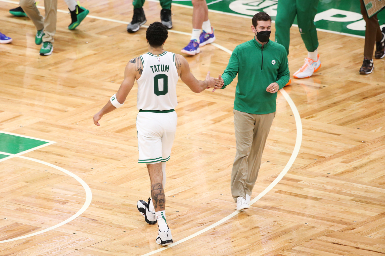 Jayson Tatum of the Boston Celtics high fives head coach Brad Stevens.