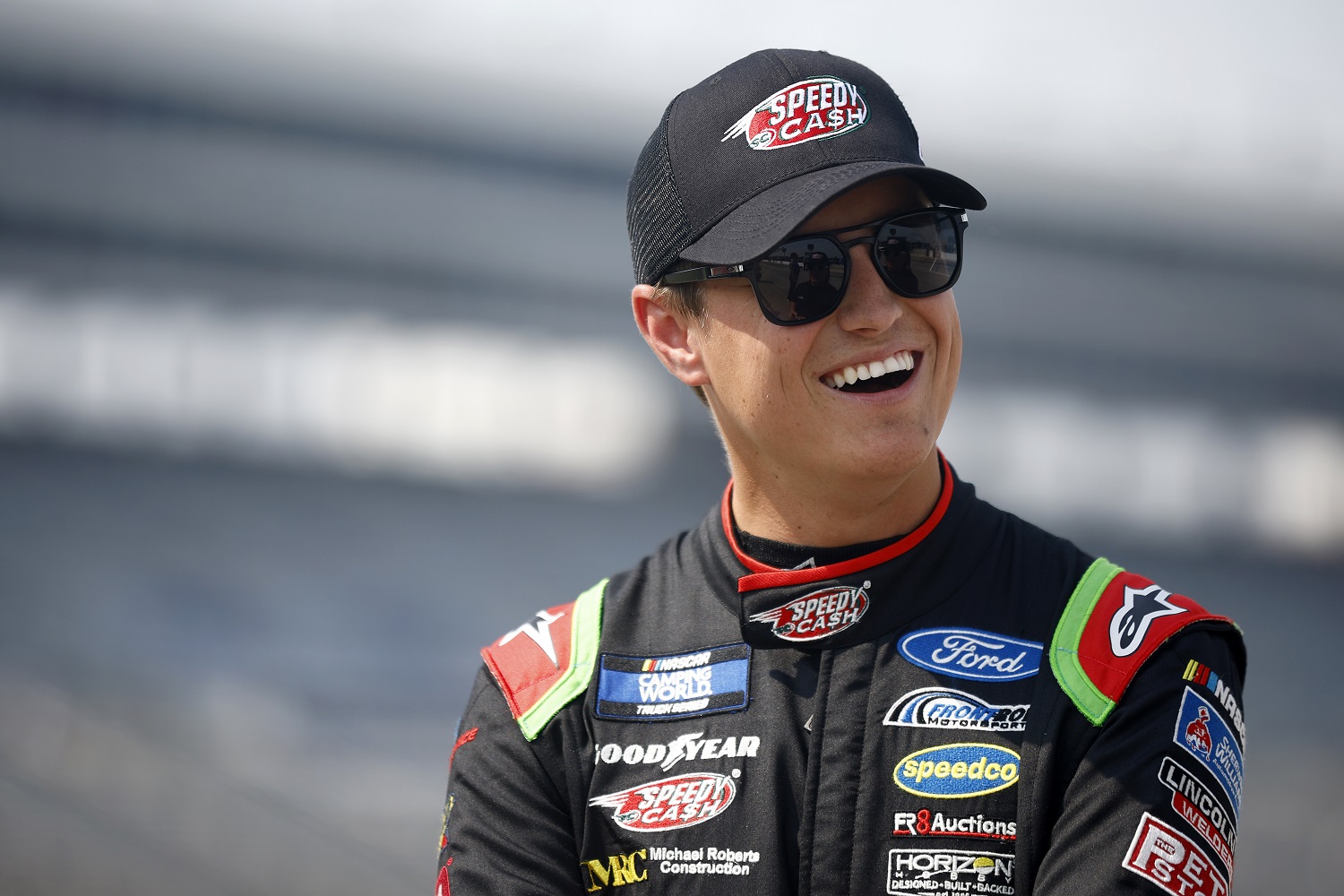 Zane Smith smiles on the grid during qualifying for the NASCAR Camping World Truck Series SpeedyCash.com 220 at Texas Motor Speedway on May 20, 2022 in Fort Worth, Texas.