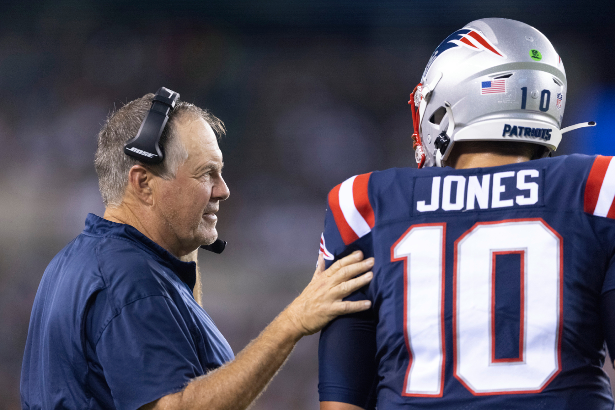 Head coach Bill Belichick of the New England Patriots talks to Mac Jones.