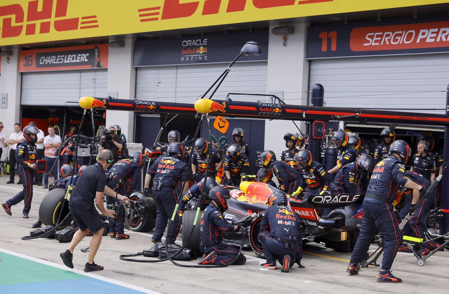 Technicians work on the car of Red Bull Racing's Sergio Perez at a pit stop on the Red Bull Ring race track in Spielberg, Austria, during the Formula 1 Austrian Grand Prix on July 10, 2022.