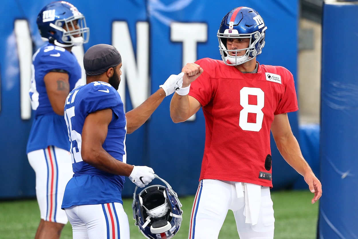 Daniel Jones and Golden Tate of the New York Giants bump fists.