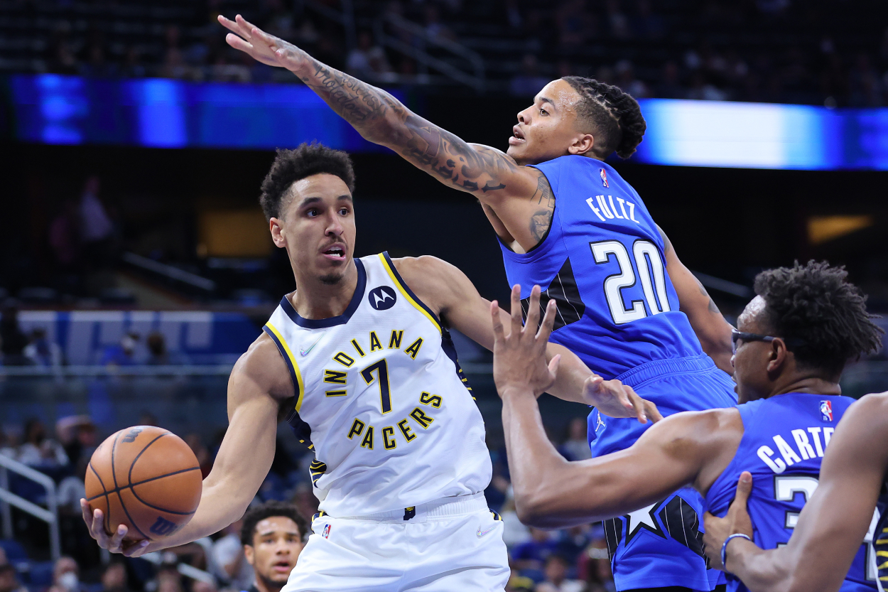 Malcolm Brogdon of the Indiana Pacers throws a pass around Markelle Fultz.