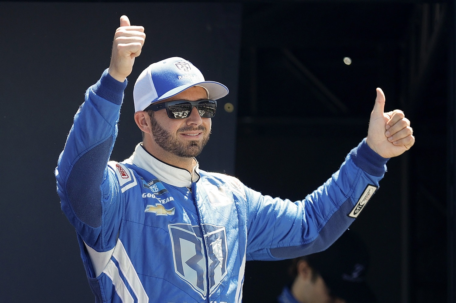 Matt DiBenedetto gives a thumbs-up to fans onstage during driver intros prior to the NASCAR Camping World Truck Series CRC Brakleen 150 at Pocono Raceway on July 23, 2022.