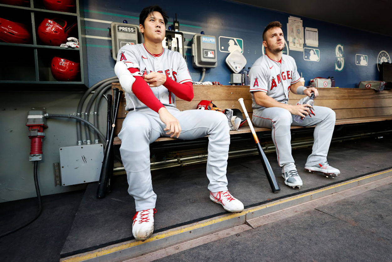 Shohei Ohtani (L) and Mike Trout (R) sit in the dugout during a Los Angeles Angels game.