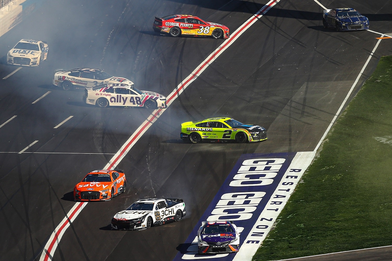 Denny Hamlin, driver of the No. 11 Toyota; Tyler Reddick, driver of the No. 8 Chevrolet; Chris Buescher, driver of the No. 17 Ford; Austin Cindric, driver of the No. 2 Ford; Alex Bowman, driver of the No. 48 Chevrolet; Michael McDowell, driver of the No. 34 Ford; and Todd Gilliland, driver of the No. 38 Ford, spin after an on-track incident during the NASCAR Cup Series Folds of Honor QuikTrip 500 at Atlanta Motor Speedway on March 20, 2022.