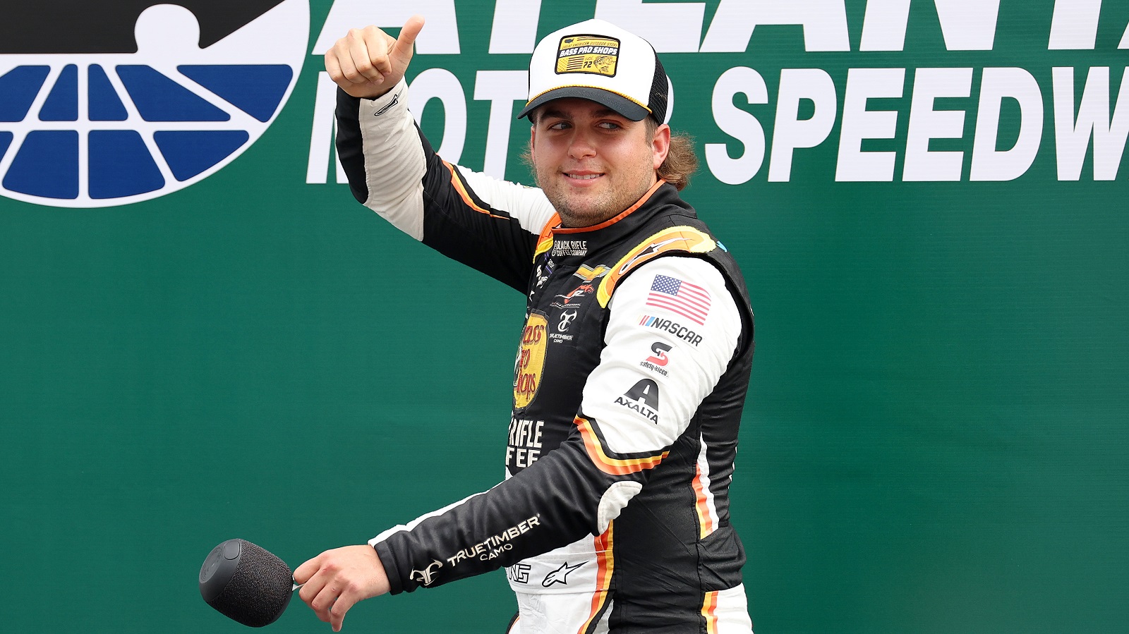 Noah Gragson waves to fans as he walks onstage during driver intros prior to the NASCAR Xfinity Series Alsco Uniforms 250 at Atlanta Motor Speedway on July 9, 2022.