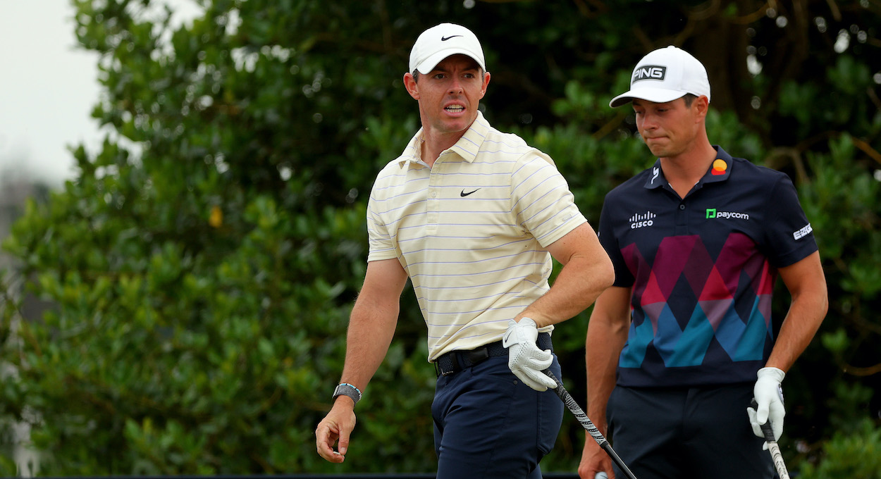 Rory McIlroy and Viktor Hovland look on.