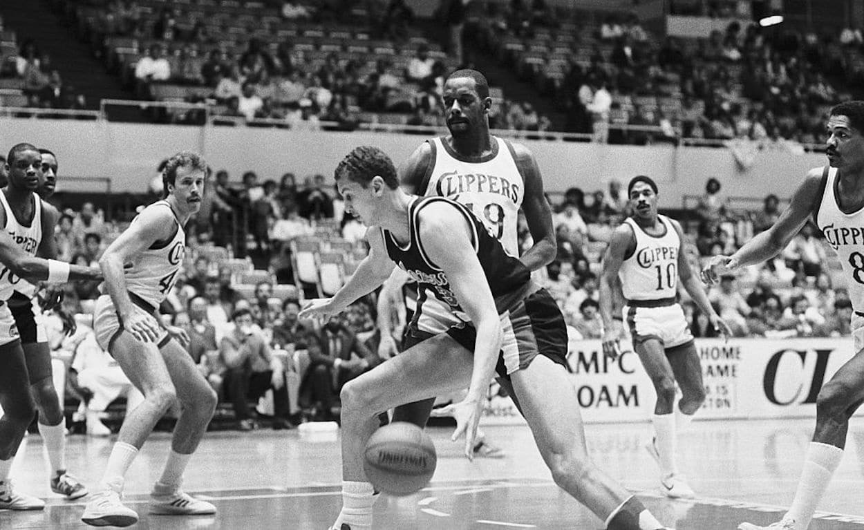 Portland Trail Blazers big man Sam Bowie (C) dribbles the ball.