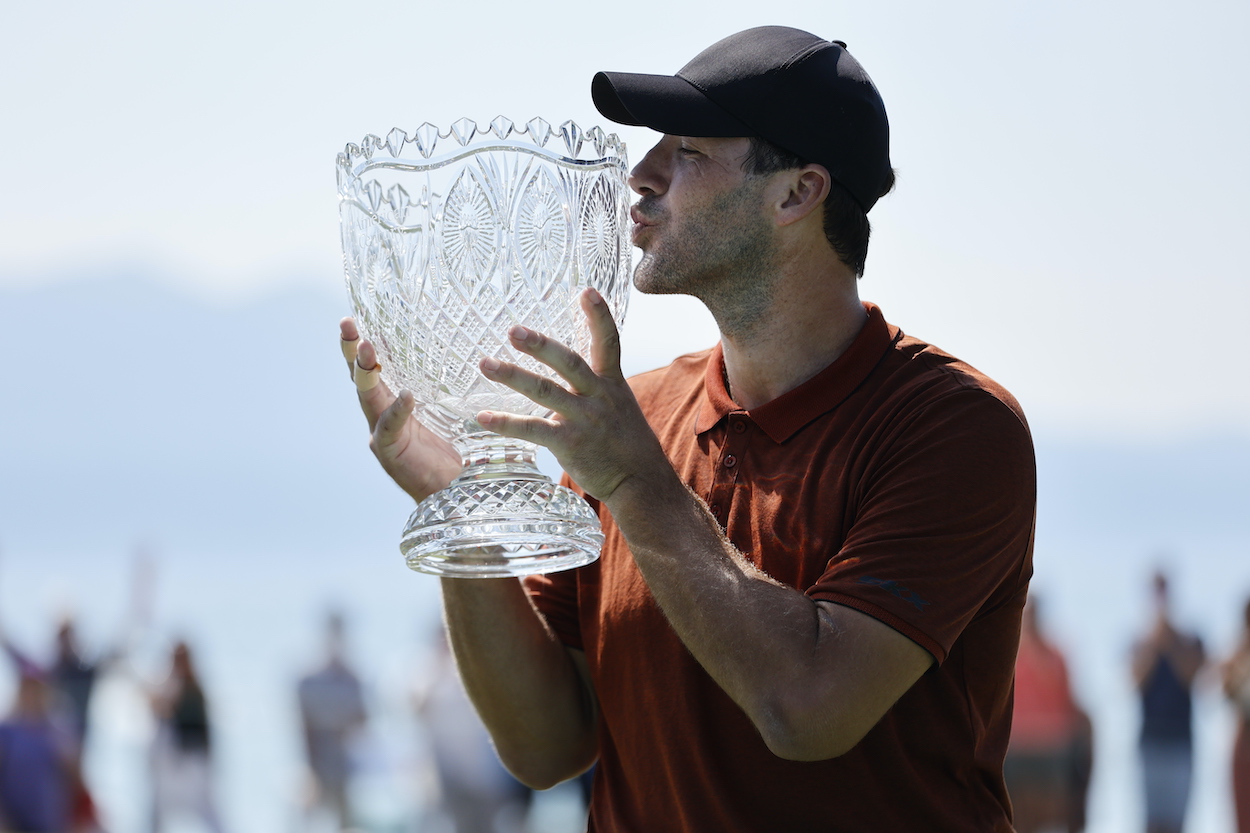 Former NFL quarterback Tony Romo kisses the trophy after winning the American Century Championship.