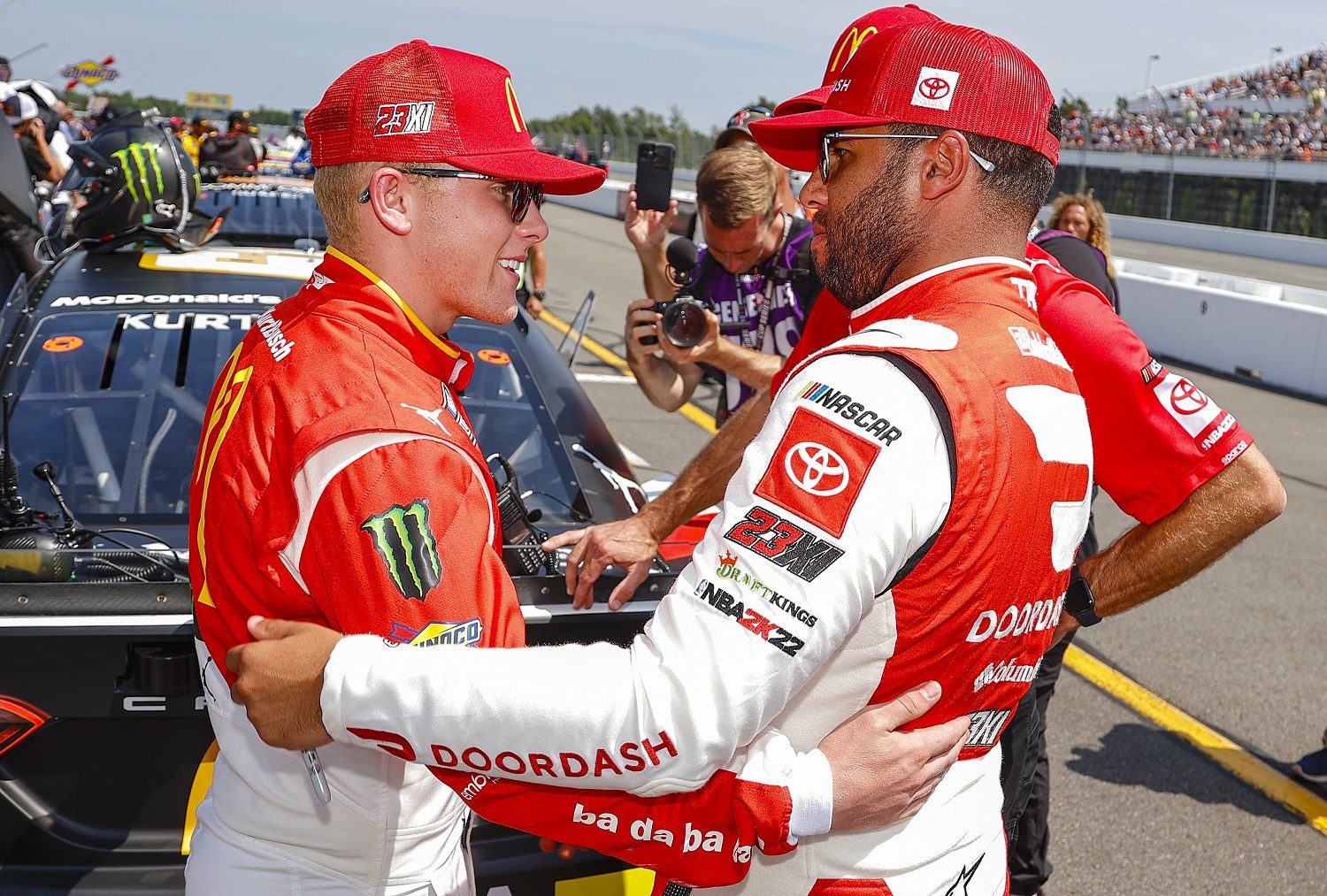 Ty Gibbs and Bubba Wallace talk on the grid prior to the NASCAR Cup Series M&M's Fan Appreciation 400 at Pocono Raceway on July 24, 2022.