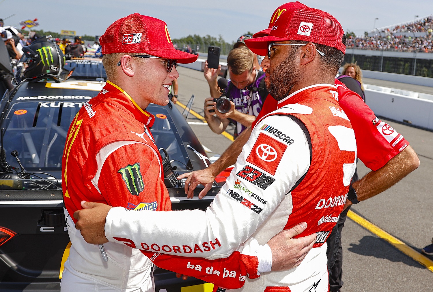 Ty Gibbs and Bubba Wallace talk on the grid prior to the NASCAR Cup Series M&M's Fan Appreciation 400 at Pocono Raceway on July 24, 2022. | Tim Nwachukwu/Getty Images