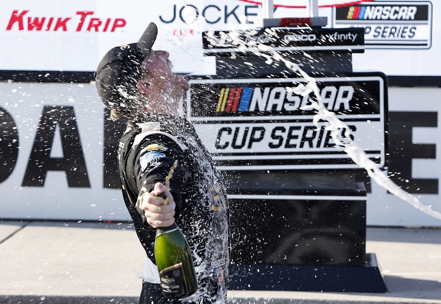 Tyler Reddick and crew celebrate by spraying champagne in Victory Lane after winning the NASCAR Cup Series Kwik Trip 250 at Road America on July 3, 2022.
