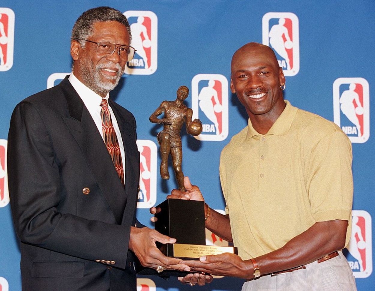 Michael Jordan (R) receives the NBA MVP trophy from Bill Russell (L).