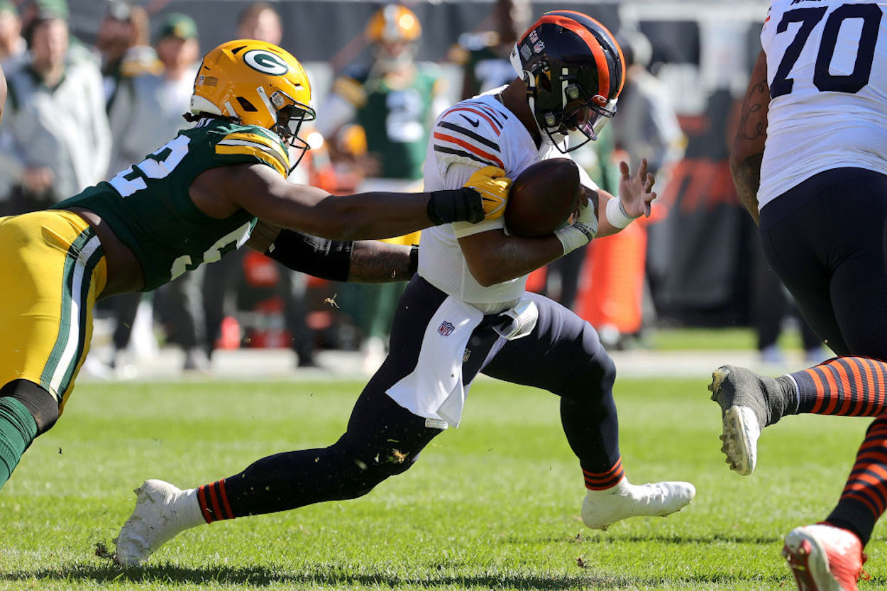 Chicago Bears' quarterback Justin Fields is tackled by a Green Bay Packers defender.