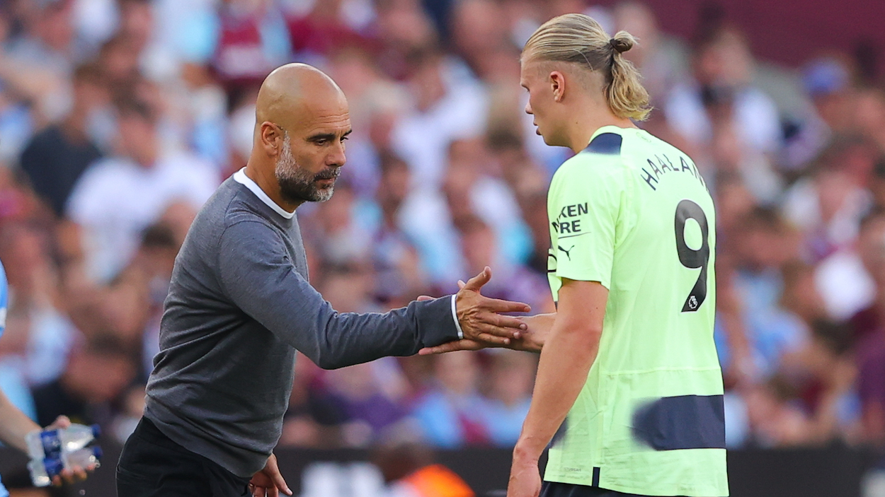 Pep Guardiola, manager of Manchester City, shakes hands with Erling Haaland during the Premier League match between West Ham United and Manchester City.