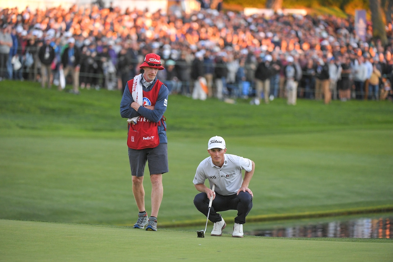 Will Zalatoris reads the green with his caddie.