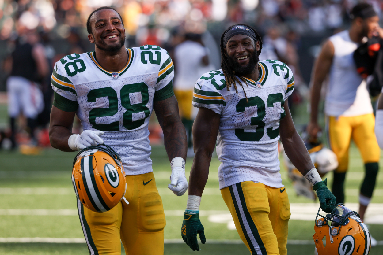 AJ Dillon #28 and Aaron Jones #33 of the Green Bay Packers walk off the field.