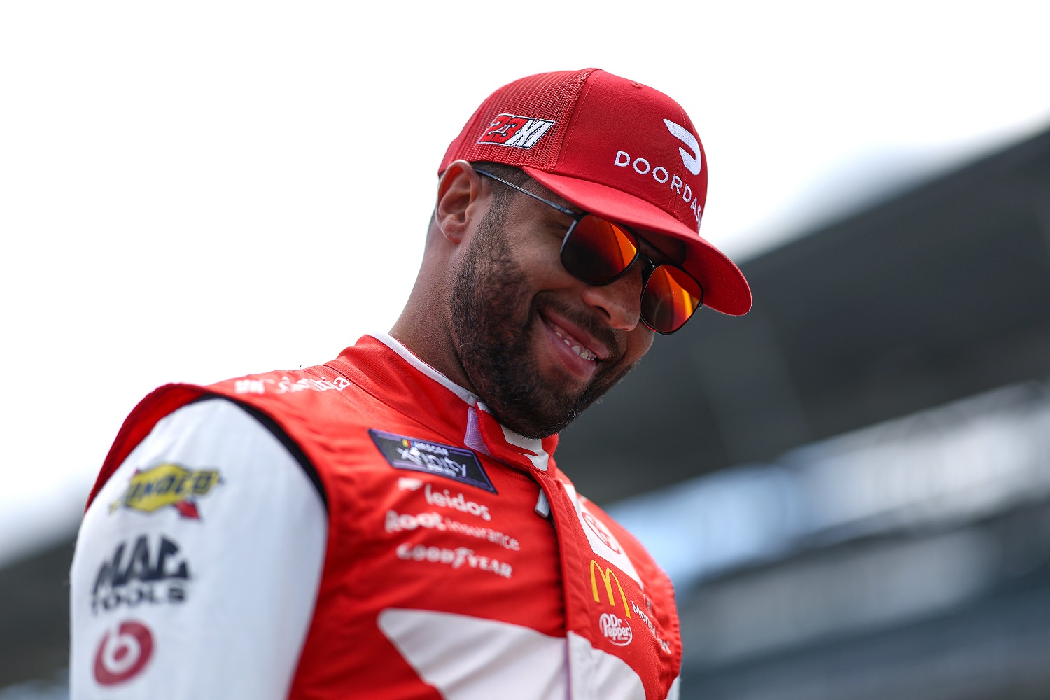 Bubba Wallace smiles on the grid during practice for the NASCAR Xfinity Series Pennzoil 150 at the Brickyard at Indianapolis Motor Speedway on July 29, 2022.