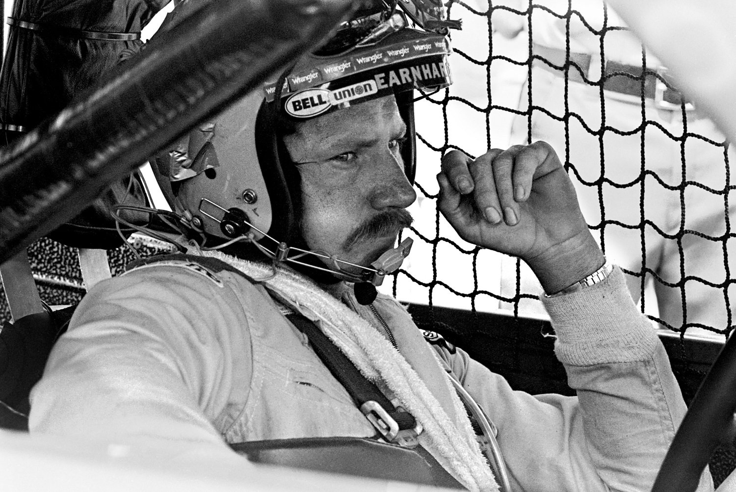 NASCAR driver Dale Earnhardt Sr. sits in his car while it is repaired after an accident during the Firecracker 400 on July 4, 1981 at the Daytona International Speedway.
