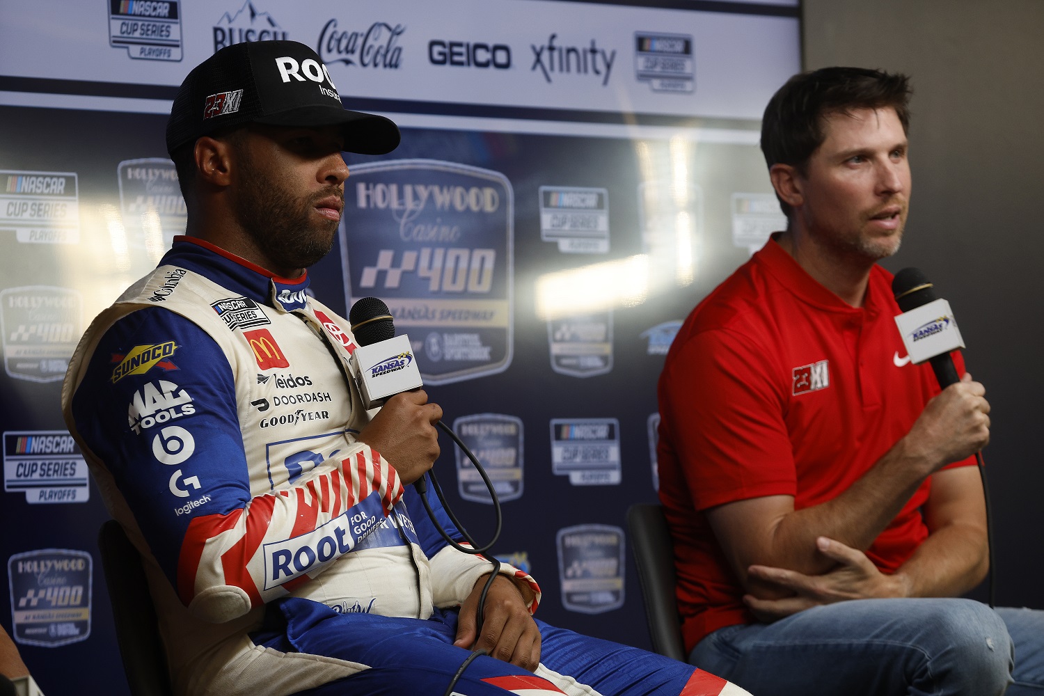 23XI Racing team co-owner Denny Hamlin and driver Bubba Wallace speak to the media during a press conference after winning the NASCAR Cup Series Hollywood Casino 400 at Kansas Speedway on Sept. 11, 2022. | Chris Graythen/Getty Images