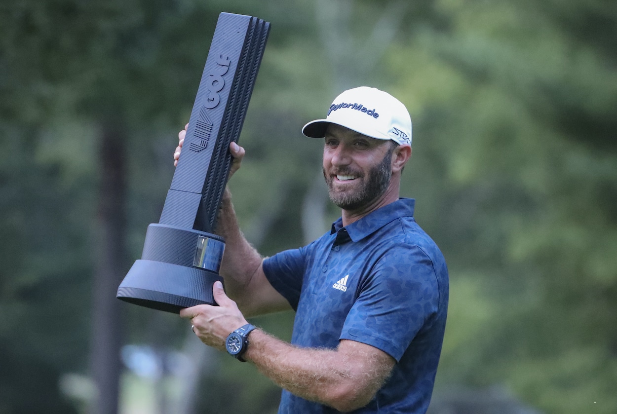 Dustin Johnson celebrates with the LIV Golf trophy.