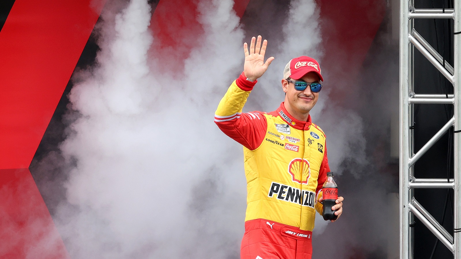 Joey Logano waves to fans as he walks onstage during driver intros prior to the NASCAR Cup Series Coke Zero Sugar 400 at Daytona International Speedway on Aug. 28, 2022. | James Gilbert/Getty Images