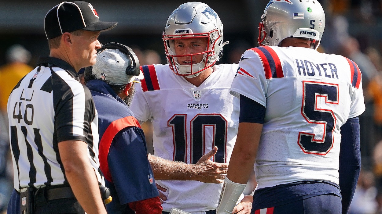 New England Patriots' Matt Patricia, senior football advisor/offensive line coach, talks to quarterback Mac Jones.