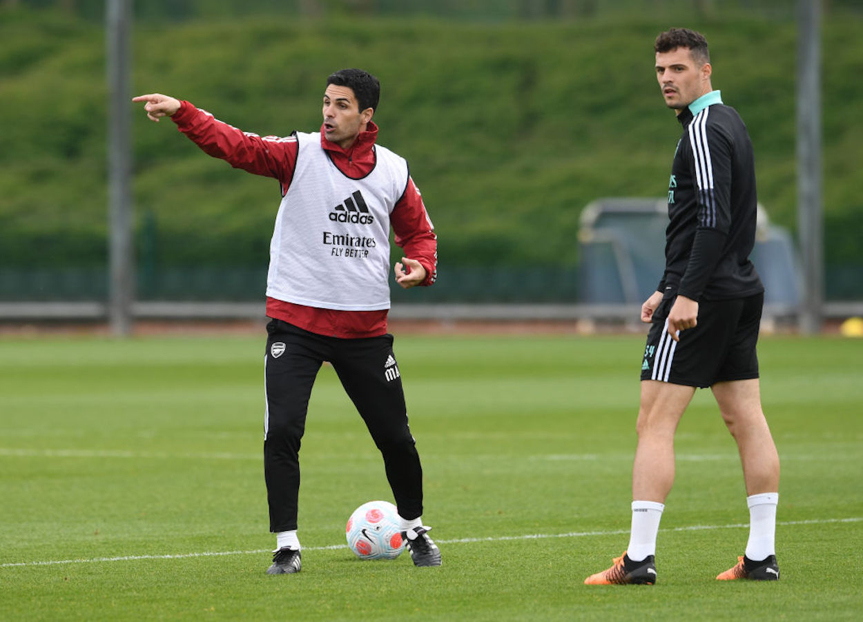 Manager Mikel Arteta (L) and midfielder Granit Xhaka (R) speak during a training session.