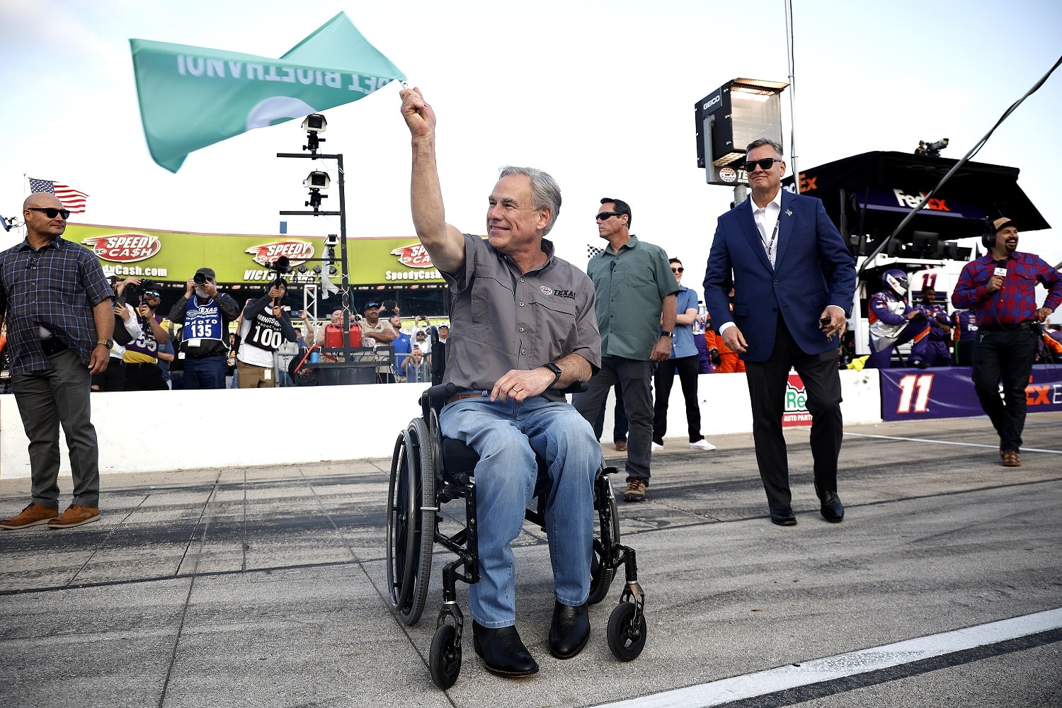 Texas Gov. Greg Abbott waves the green flag to start the NASCAR Cup Series All-Star Race at Texas Motor Speedway on May 22, 2022, in Fort Worth, Texas.