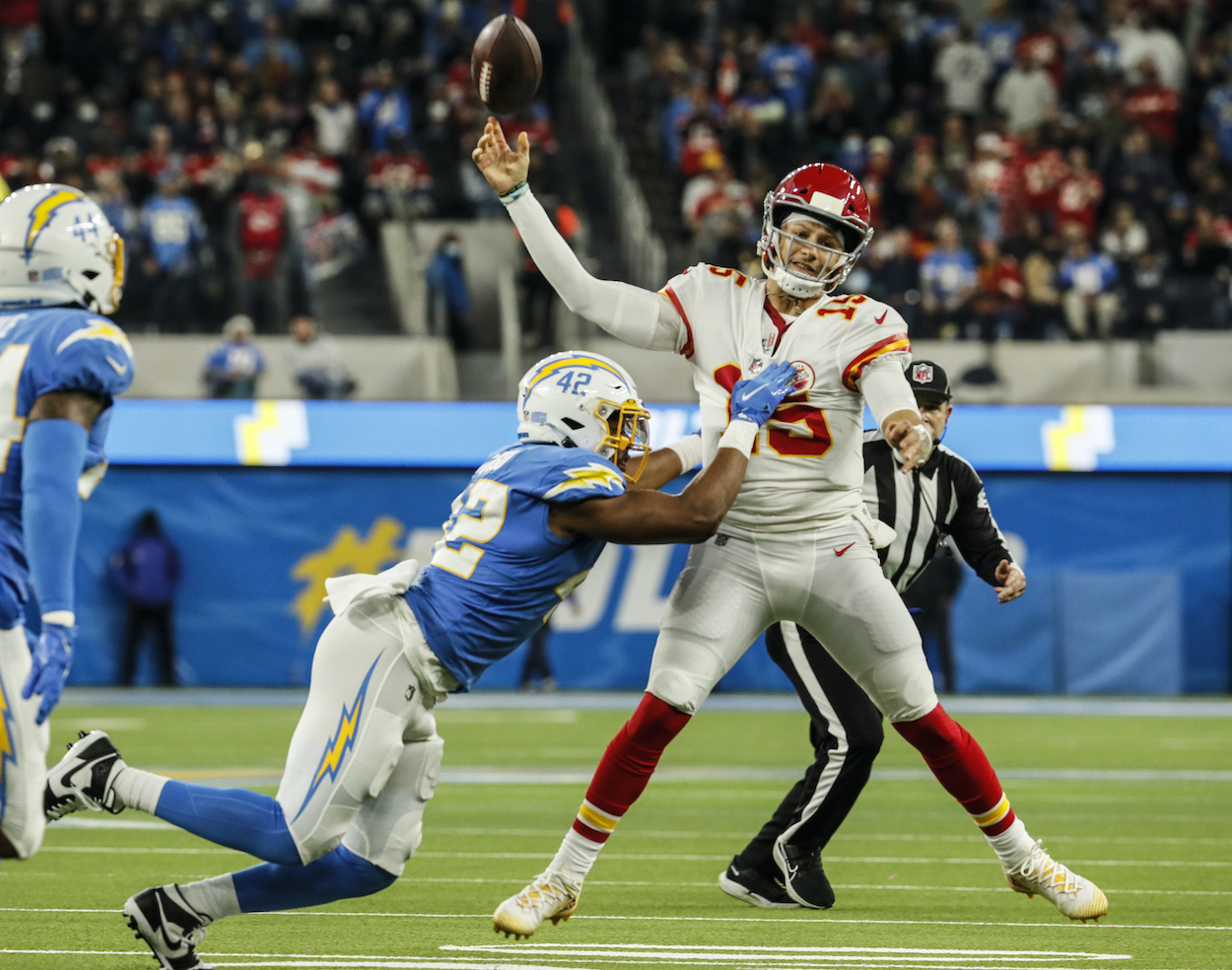 Patrick Mahomes attempts a pass while getting tackled.