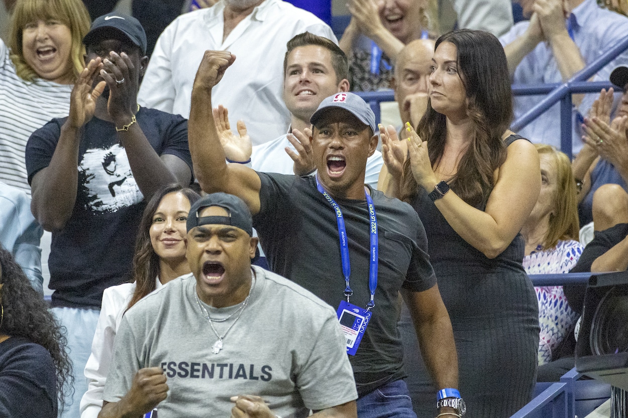 Tiger Woods fist pumps while watching Serena Williams.