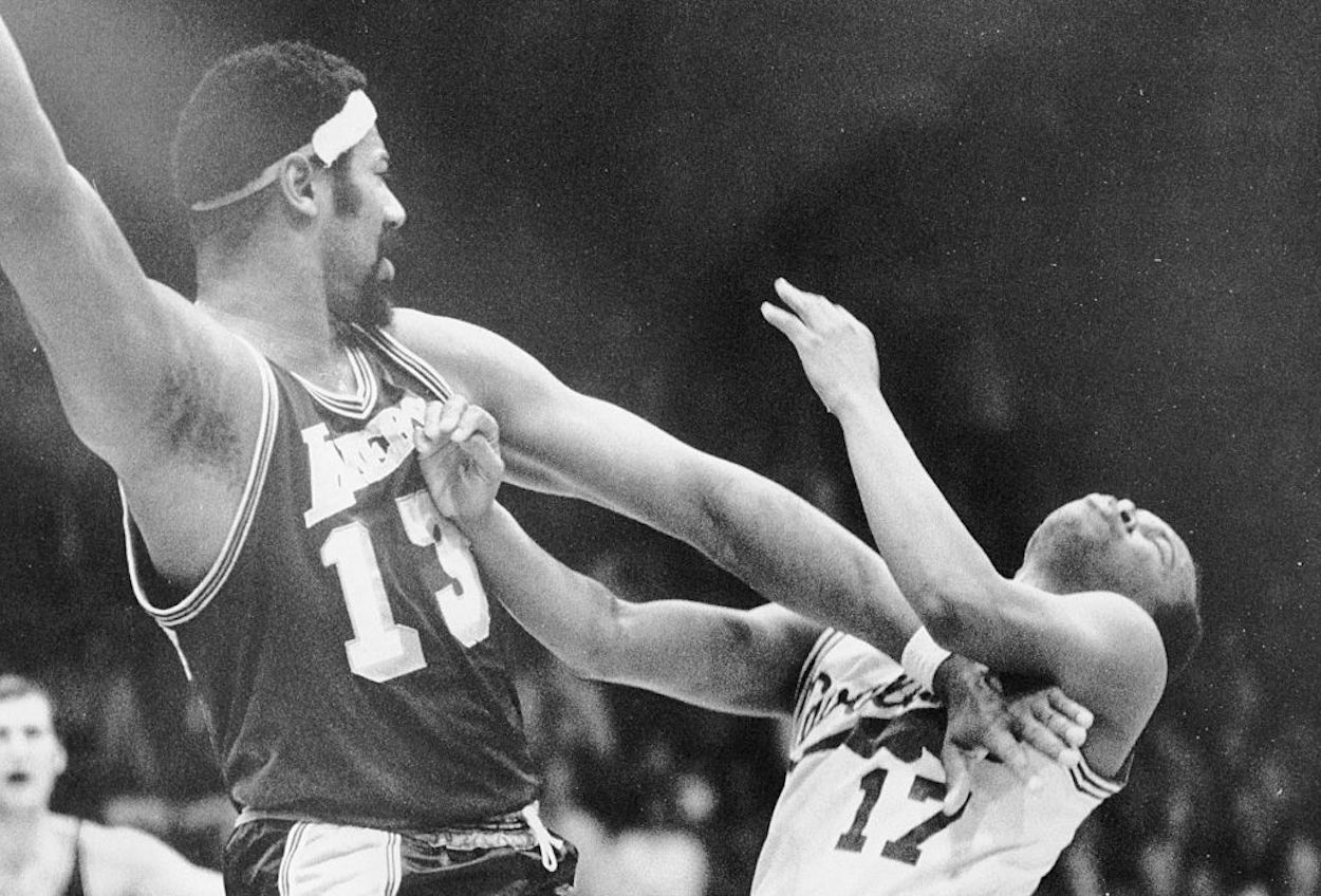 Wilt Chamberlain brushes Bobby Washington aside during an NBA game.