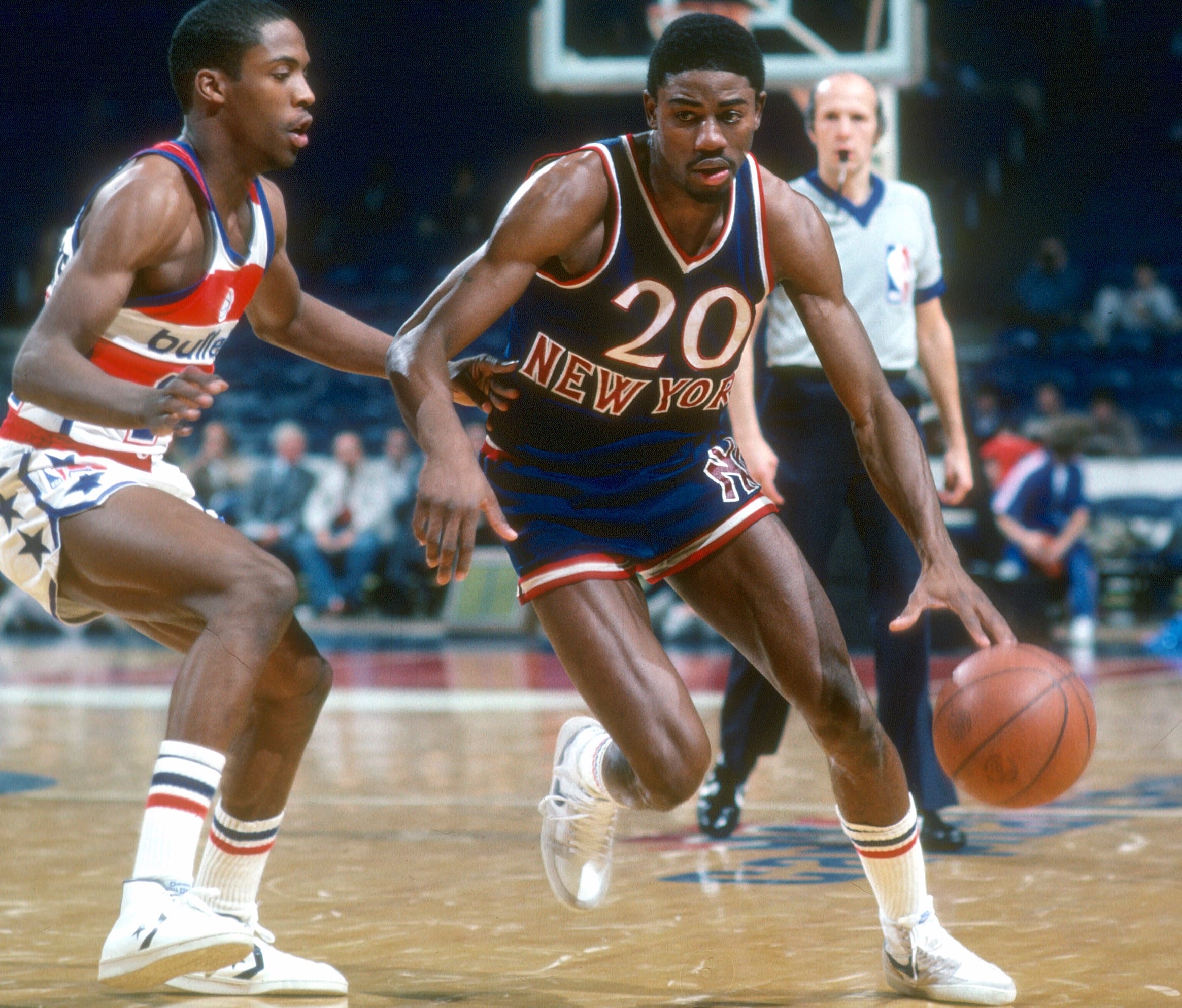 Michael Ray Richardson of the New York Knicks drives on Wes Matthews of the Washington Bullets.