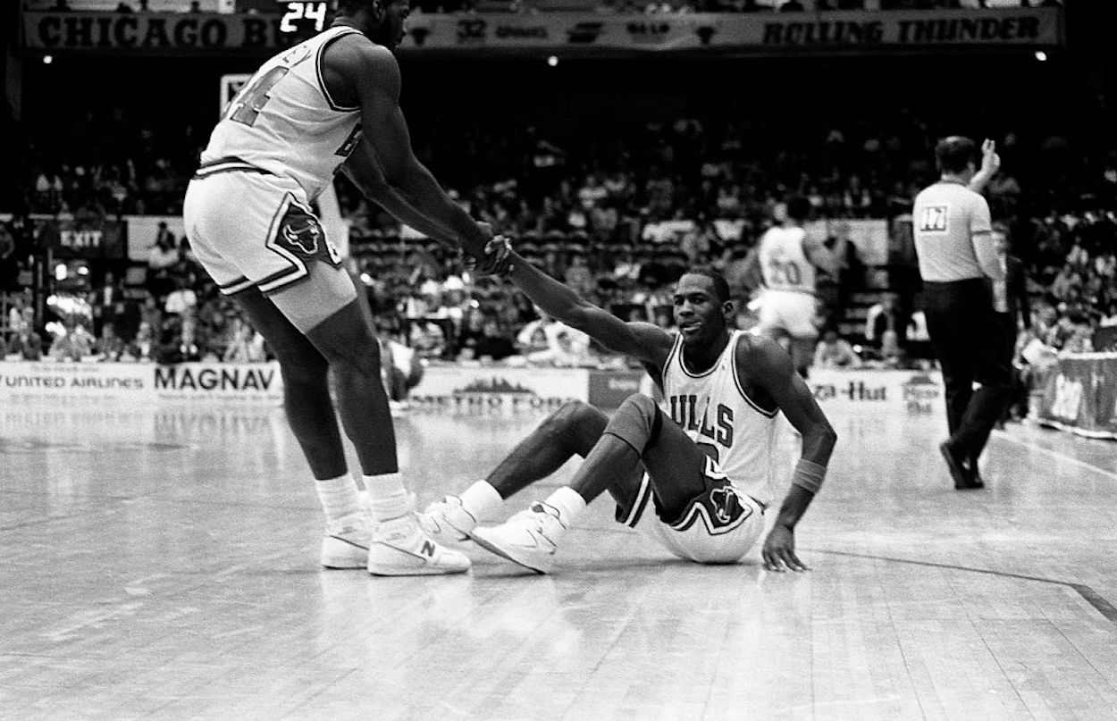 Charles Oakley (L) helps Michael Jordan (R) to his feet during their time as Chicago Bulls teammates.